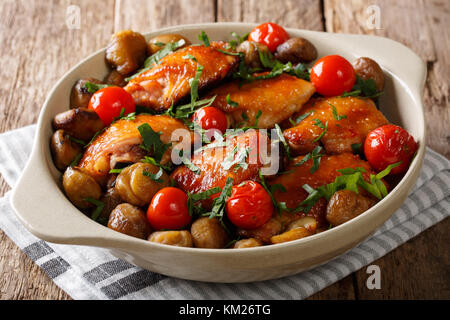 Würziges Hähnchen mit Kastanien, grünen und Tomaten close-up in einer Schale auf dem Tisch. Horizontale Stockfoto
