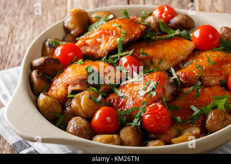 Gebratenes Huhn mit Kastanien, grünen und Tomaten close-up in einer Schüssel auf dem Tisch. Horizontale Stockfoto