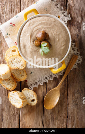 Zarte Kastaniensuppe close-up in einem Topf und Croutons auf einem Tisch. Senkrechte Draufsicht von oben Stockfoto