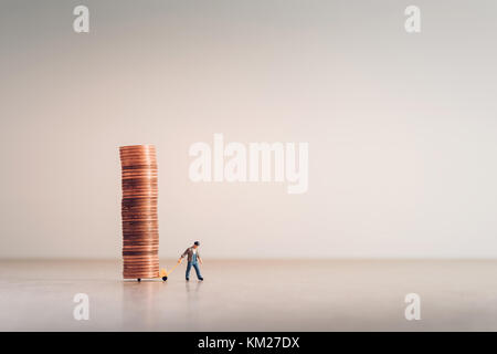 Arbeiter mit Hand-LKW voller Münzen. Stockfoto