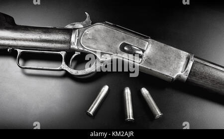 Antike 1876 Cowboy Hebelbetätigung Gewehr mit 45-60 Messing Kugeln in Schwarz und Weiß. Stockfoto