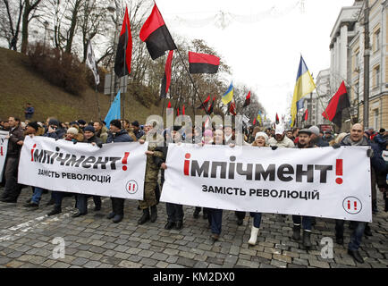 Kiew, Ukraine. Dezember 2017. Demonstranten tragen Banner mit der Aufschrift "Amtsenthebung statt Revolution", während des marsches, in dem das ukrainische parlament aufgefordert wurde, am 03. Dezember 2017 in Kiew, Ukraine, ein Gesetz über die Amtsenthebung des Präsidenten zu akzeptieren. Hunderte von verärgerten ukrainischen Aktivisten richteten am 17. Oktober 2017 außerhalb des ukrainischen Parlamentsgebäudes ein Zeltlager ein, nachdem sie von den Gesetzgebern gefordert hatten, das Gesetz über unmittelbare politische Reformen wie die Schaffung von Antikorruptionsgerichten, die Änderung der Wahlgesetze und die Entlassung der Unverletzlichkeit eines Abgeordneten anzunehmen. (Guthaben Stockfoto