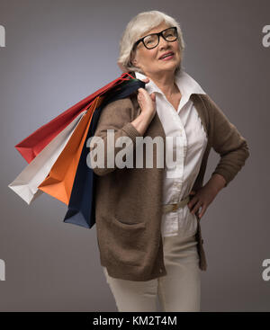 Studio Portrait von gerne ältere Frau mit Einkaufstüten Stockfoto