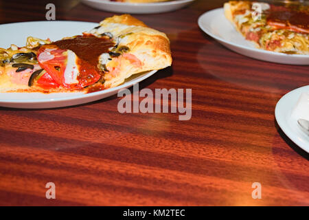 Pizza auf einem Schild an einem Tisch in einem Cafe Stockfoto