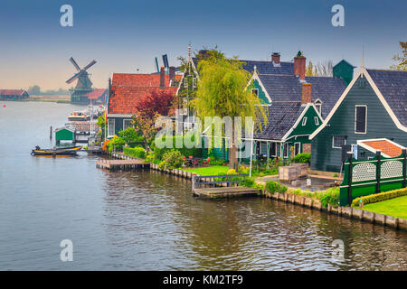 Die besten touristischen Dorf Zaanse Schans mit bunten Häusern, Gärten und alten traditionellen Windmühlen im Hintergrund auf dem Wasser, Kanäle, Niederlande, EU Stockfoto