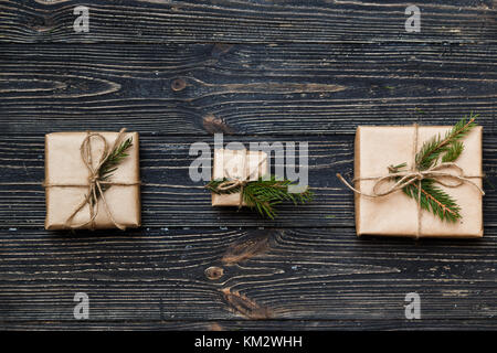 Drei Vintage Geschenkboxen mit Niederlassungen Fichte auf hölzernen Hintergrund Stockfoto
