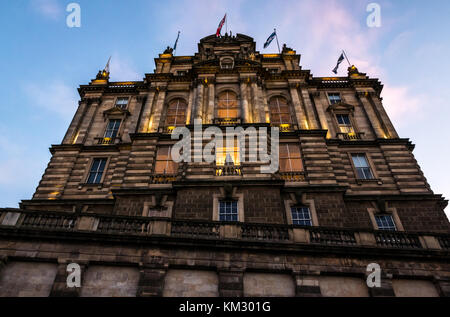 Viktorianisches Gebäude Bank von Schottland Hauptquartier, die Hügel, die in der Dämmerung mit Weihnachtsbaum in Fenster und flags Flying, Edinburgh, Schottland, Großbritannien Stockfoto