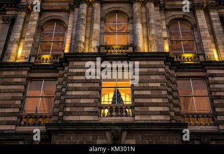 In der Nähe der viktorianischen Gebäude, Bank von Schottland Hauptquartier, die Hügel, die in der Dämmerung mit Weihnachtsbaum in Fenster, Edinburgh, Schottland, Großbritannien Stockfoto