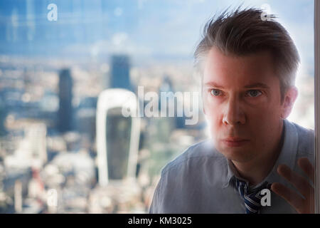 Reflektion von einem kaukasischen Geschäftsmann durch ein Fenster Stockfoto