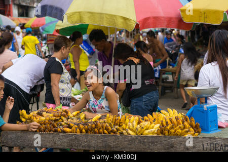 Junge Mädchen lächelnd lachend hinter einem Stall verkaufen Bananen in den CO2-Markt, Cebu City Stockfoto