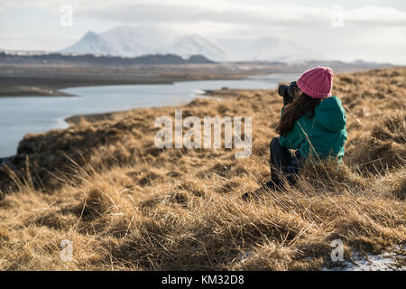 Fotograf sitzt auf braunem Gras im Freien Stockfoto