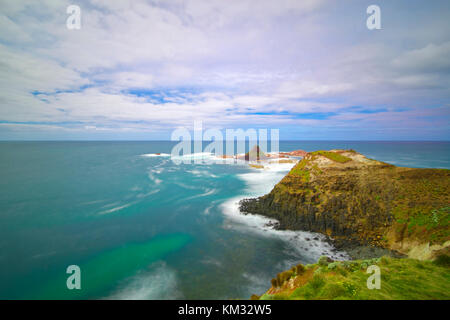 Rocky Küste mit pyramidenförmigen Insel Stockfoto