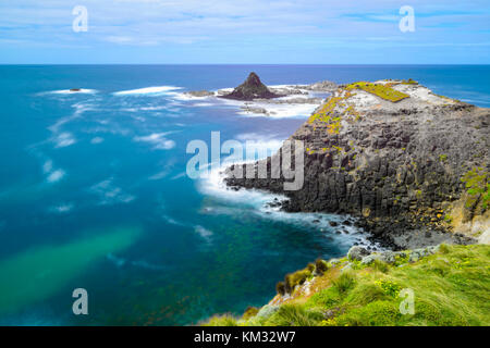 Rocky Küste mit pyramidenförmigen Insel Stockfoto