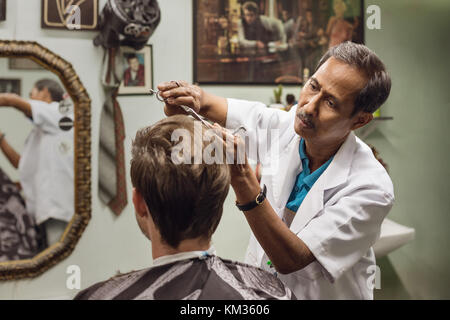 Malaiische Friseur- Konzentration bei der Arbeit Stockfoto