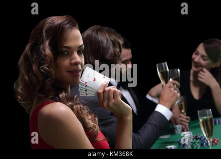 Frau am Roulette Tisch holding Champagner Glas in Casino Stockfoto