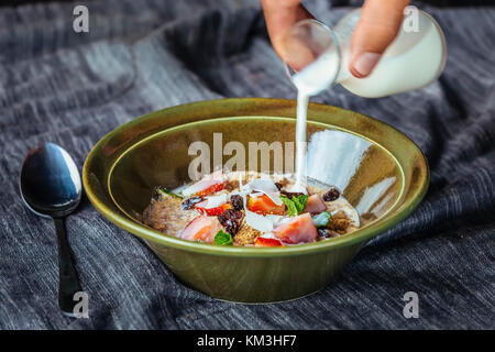 Müsli. Müsli mit Milch und Beeren auf dem Tisch. Stockfoto