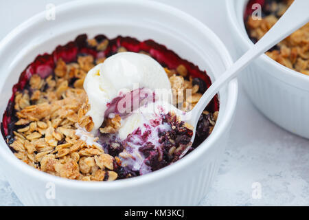 Berry Crumble mit Sahne Eis in eine keramische Form. Stockfoto