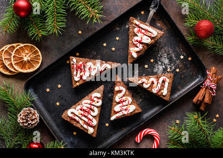 Chocolate brownies in Form der Weihnachtsbaum mit Frischkäse und festliche Streuseln. Ansicht von oben. Süße Weihnachten oder Winter Urlaub essen Stockfoto