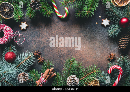 Weihnachten Rahmen mit Fir Tree Branches, Zuckerstangen, Gingerbread cookies, Gewürze und getrocknete Orangen. Kopieren Sie Platz für Text Stockfoto