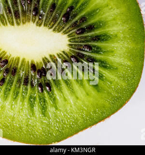 Teil einer Scheibe der Kiwi auf weißem Hintergrund, Ansicht von oben, quadratischen Format. Close-up. Stockfoto