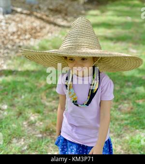 Junge Mädchen mit einem Sombrero zu Fuß in einer Vorstadtstraße, Townsville, Queensland, Australien Stockfoto