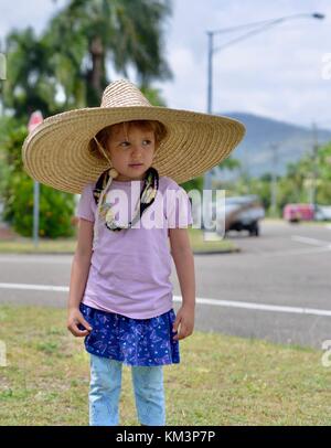 Junge Mädchen mit einem Sombrero zu Fuß in einer Vorstadtstraße, Townsville, Queensland, Australien Stockfoto