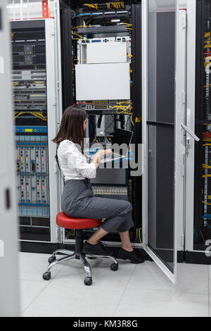 Portrait von Techniker arbeiten am Laptop im Server Raum Stockfoto