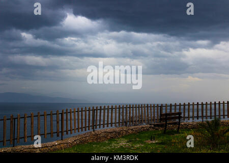 Winterlandschaft Panorama vor dem Sturm mit Blick auf das Meer und die Wolken von oben gesehen und einen leeren Bank Griechenland Stockfoto