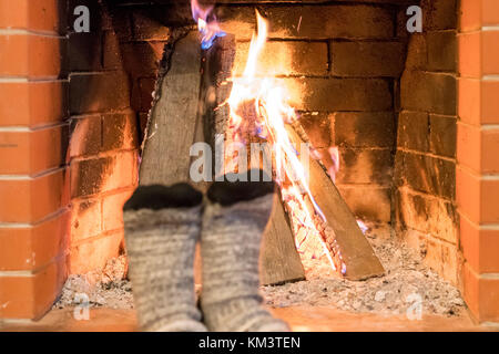 Die Füße im warmen Socken am Kamin Stockfoto