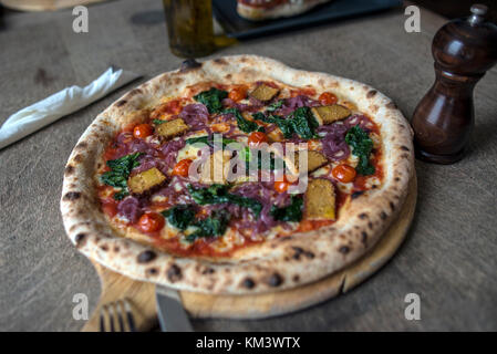 Authentische italienische Pizza auf Rustikale Oberfläche Stockfoto