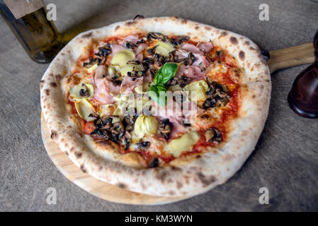 Authentische italienische Pizza auf Rustikale Oberfläche Stockfoto