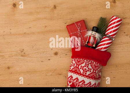 Weihnachtsstrumpf mit Cracker, Spielzeug und Wickelte vorhanden Stockfoto