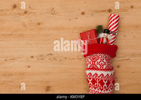 Weihnachtsstrumpf mit Cracker, Spielzeug und Wickelte vorhanden Stockfoto