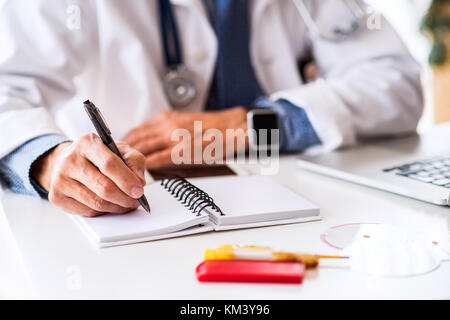 Leitender Arzt am Schreibtisch arbeiten. Stockfoto