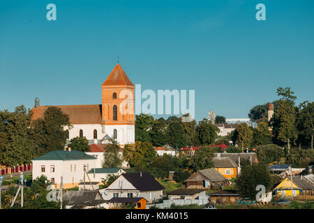 Mir, Weißrussland. Landschaft Der Dorfhäuser Und Der Römisch-Katholischen Kirche St. Nicolas Am Sonnigen Sommertag In Mir, Weißrussland. Berühmtes Wahrzeichen. Historischer Bogen Stockfoto