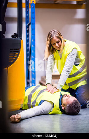 Das lagerpersonal nach einem Unfall in einem Lager. Stockfoto