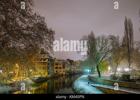 Alte Fachwerkhäuser framing Häuser im Viertel Petite France, Straßburg. schneebedeckte Dächer und refctions im Fluss Wasser. Nacht Szene. Weihnachtszeit. Stockfoto