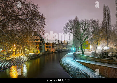 Alte Fachwerkhäuser framing Häuser im Viertel Petite France, Straßburg. schneebedeckte Dächer und refctions im Fluss Wasser. Nacht Szene. Weihnachtszeit. Stockfoto