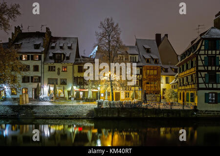 Alte Fachwerkhäuser framing Häuser im Viertel Petite France, Straßburg. schneebedeckte Dächer und refctions im Fluss Wasser. Nacht Szene. Weihnachtszeit. Stockfoto