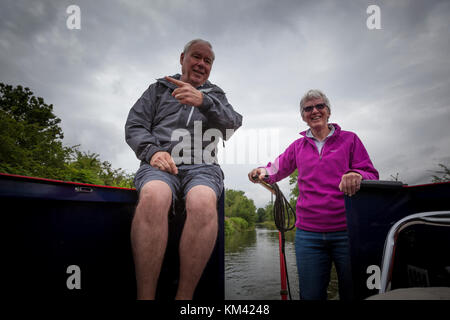 Ein Mann sitzt an der Rückseite eines 15-04, während eine Frau lenkt mit der Deichsel, Trent & Mersey Canal, Staffordshire, England Stockfoto