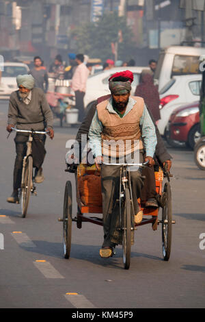 Punjabi sikh Mann mit Turban und Bart Pedale cycle rickshaw mit Passagier, in Amritsar, Indien Stockfoto