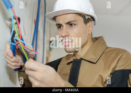 Elektriker Kabel an der Buchse im neuen Gebäude. Stockfoto