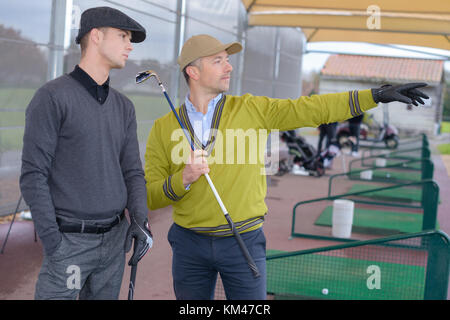 Zwei lächelnde Männer Golfspieler Gespräch am Golfplatz Stockfoto