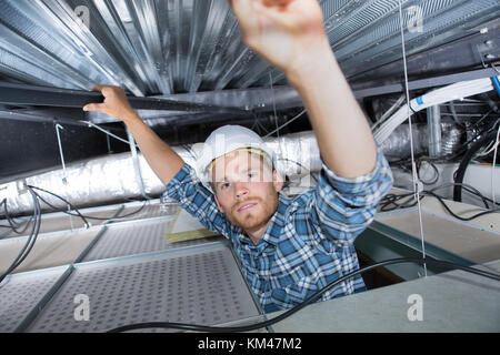 Handwerker suchen mit Metallstangen in der Decke Stockfoto