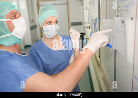 Weibliche Chirurg Kontrolle der Planung in der Chirurgie im Tagungsraum Stockfoto