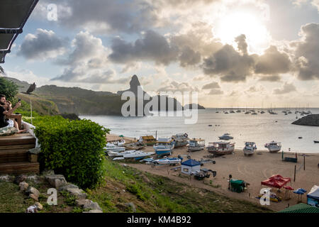 Sonnenuntergang Blick auf Praia do Porto und Hafen von Santo Antonio mit Morro pico auf dem Hintergrund von mergulhao Restaurant - Fernando de Noronha, Brasilien Stockfoto