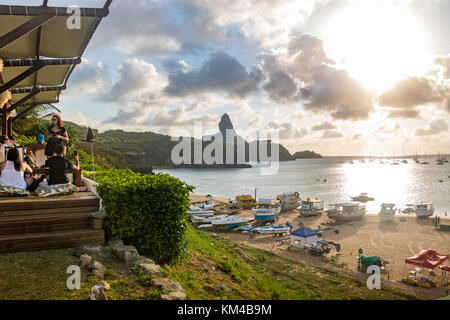 Sonnenuntergang Blick auf Praia do Porto und Hafen von Santo Antonio mit Morro pico auf dem Hintergrund von mergulhao Restaurant - Fernando de Noronha, Brasilien Stockfoto