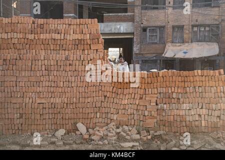 Für den Wiederaufbau von Bhaktapur nach den Erdbeben von 2015 werden Ziegelsteine aus Schutt geborgen und zu einer Mauer gestapelt. (07. Dezember 2016) | Nutzung weltweit Stockfoto