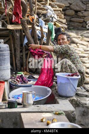 Eine Frau wäscht Wäsche auf einem typischen Waschplatz auf einer Straße in der Nähe von Kathmandu. (25. November 2016) | Verwendung weltweit Stockfoto