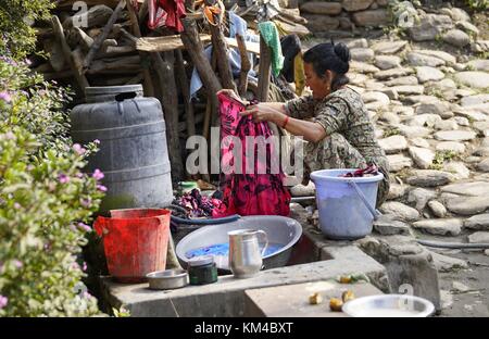 Eine Frau wäscht Wäsche auf einem typischen Waschplatz auf einer Straße in der Nähe von Kathmandu. (25. November 2016) | Verwendung weltweit Stockfoto